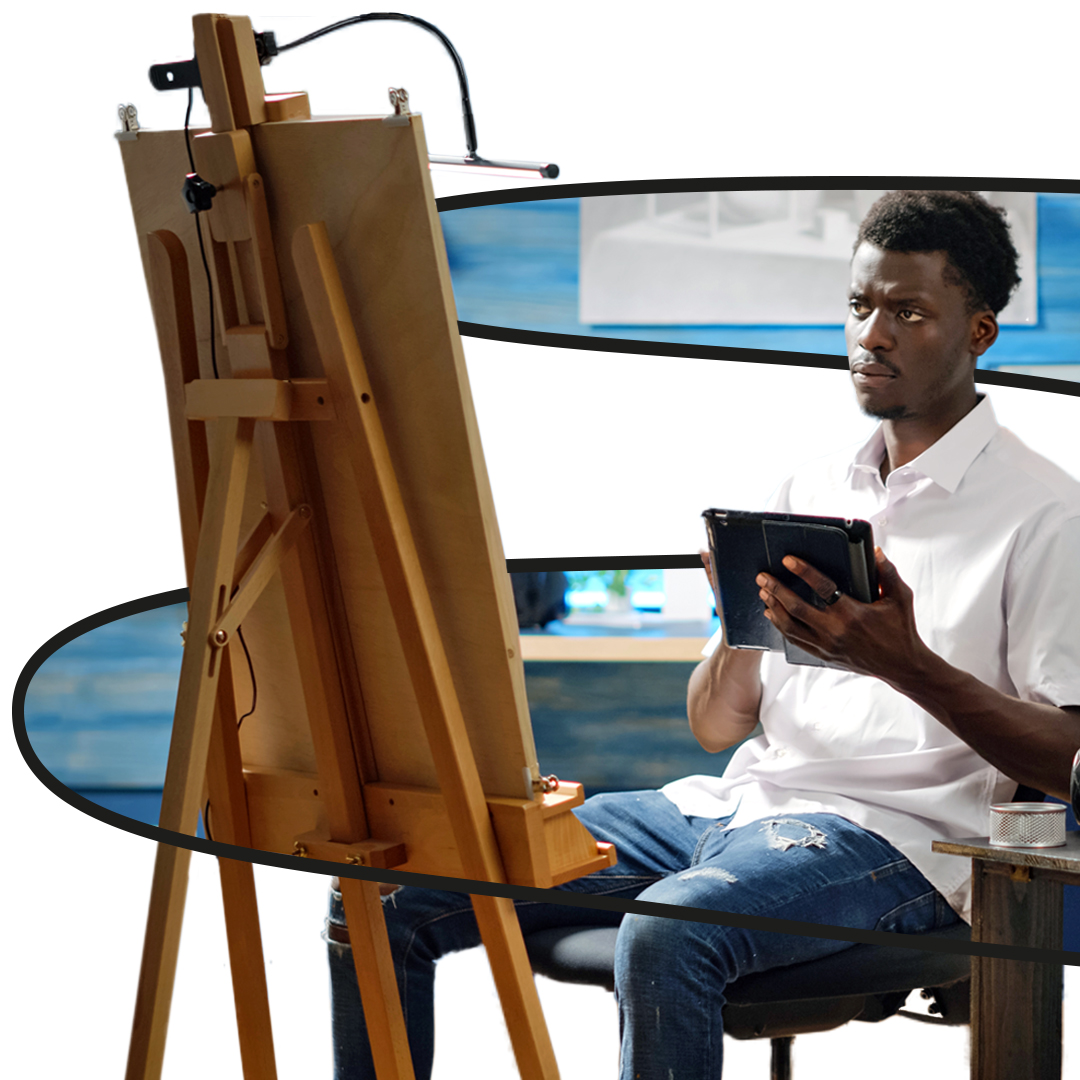 Ilustração com a foto de um homem jovem negro sentado adiante de um tripé com um quadro. Ele está segurando um tablet.